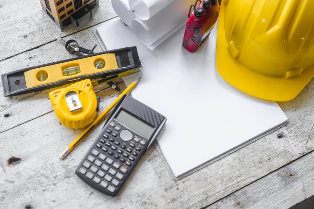 A messy collection of standard tools including a tape measure, bubble level, and pencil